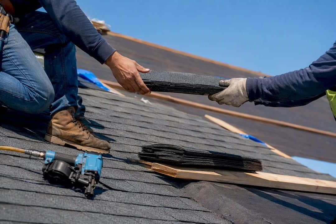 Roofing crew hands installing shingles